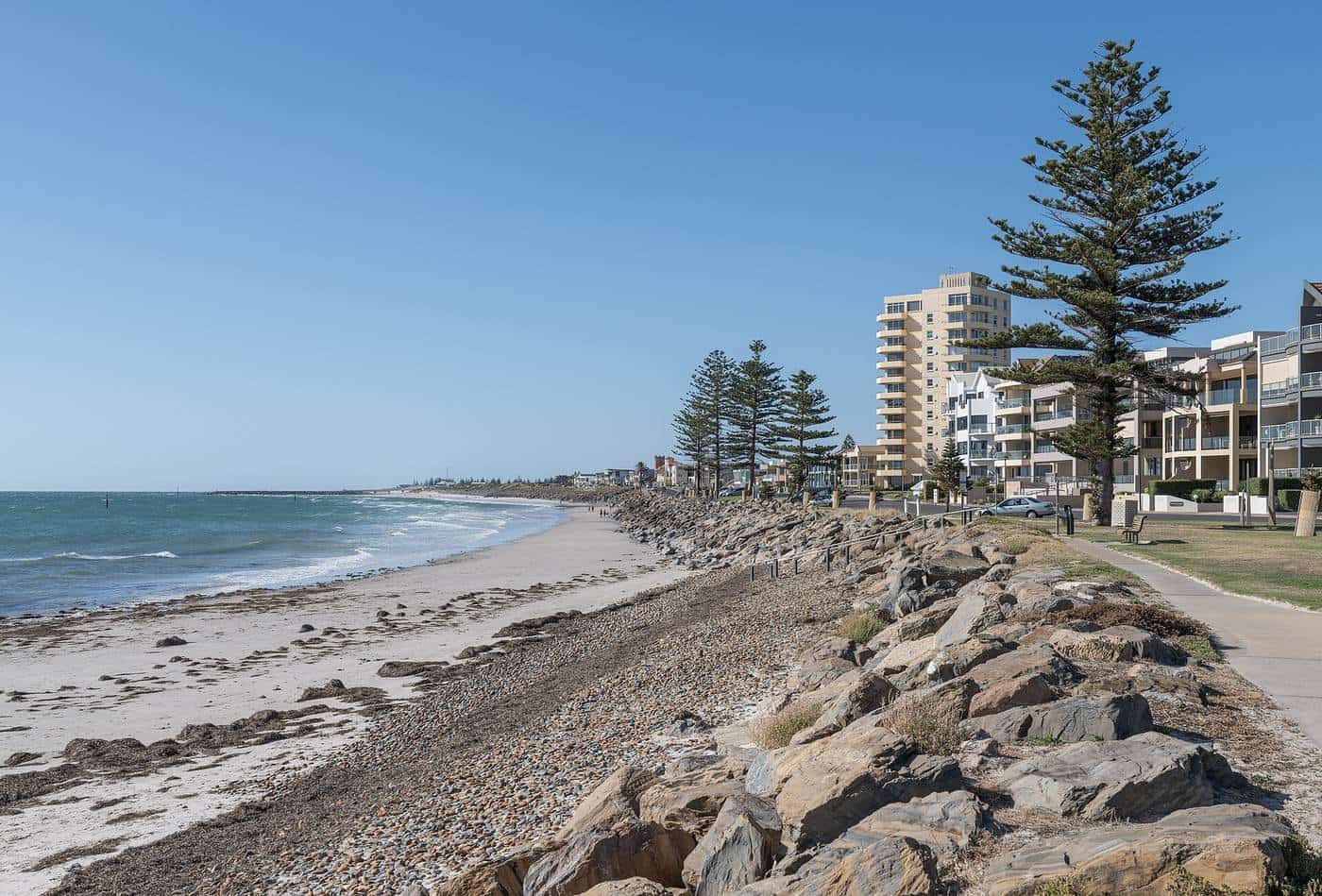 Glenelg North beach with sand, rocks and a seaside path